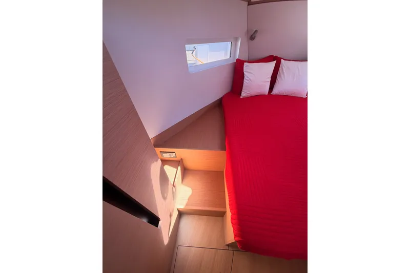 Slide: The Image of Cozy cabin interior of 2024 Jeanneau Sun Odyssey 380 with red bedding and wooden accents. - 70