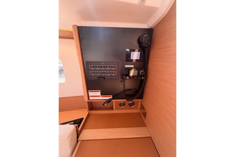 Slide: The Image of Control panel inside 2024 Jeanneau Sun Odyssey 380 yacht, featuring navigation and communication equipment. - 61
