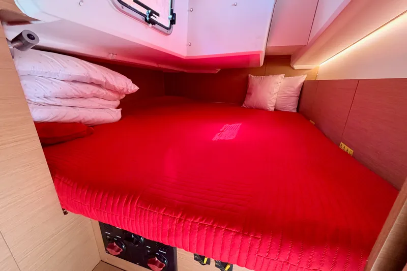 Slide: The Image of Cozy cabin interior of 2024 Jeanneau Sun Odyssey 380 with red bedding and pillows. - 49