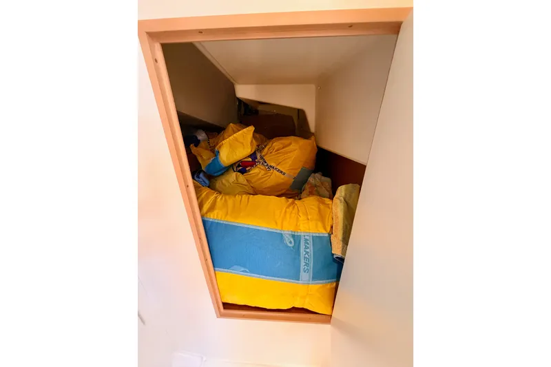 Slide: The Image of Storage compartment with colorful life jackets on Jeanneau Sun Odyssey 380, 2024 model. - 54