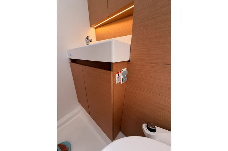 Slide: The Image of 2024 Jeanneau Sun Odyssey 380 bathroom with modern sink and wooden cabinetry. - 58