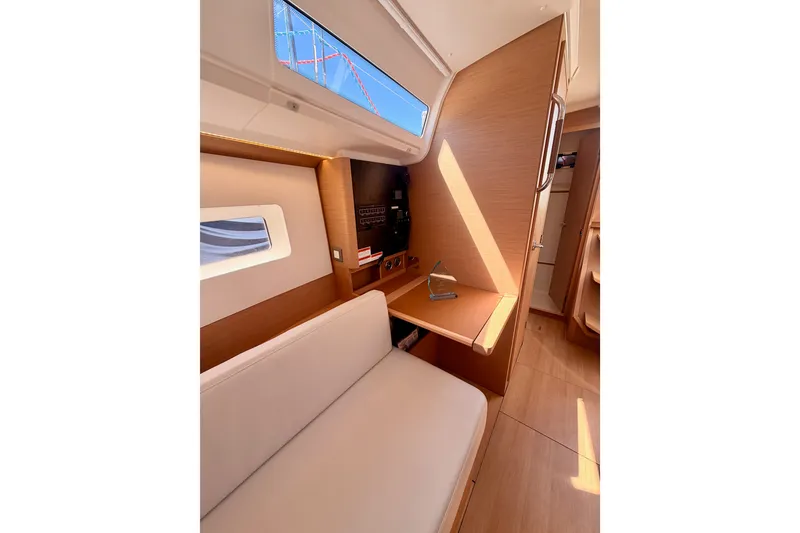 Slide: The Image of Interior of 2024 Jeanneau Sun Odyssey 380 yacht, featuring modern wood finish and seating area. - 74