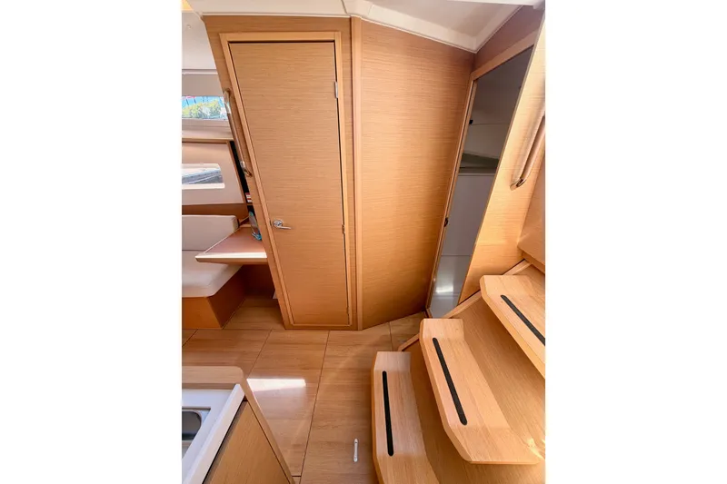 Slide: The Image of Interior of 2024 Jeanneau Sun Odyssey 380 sailboat, featuring wooden cabinetry and stairs. - 52