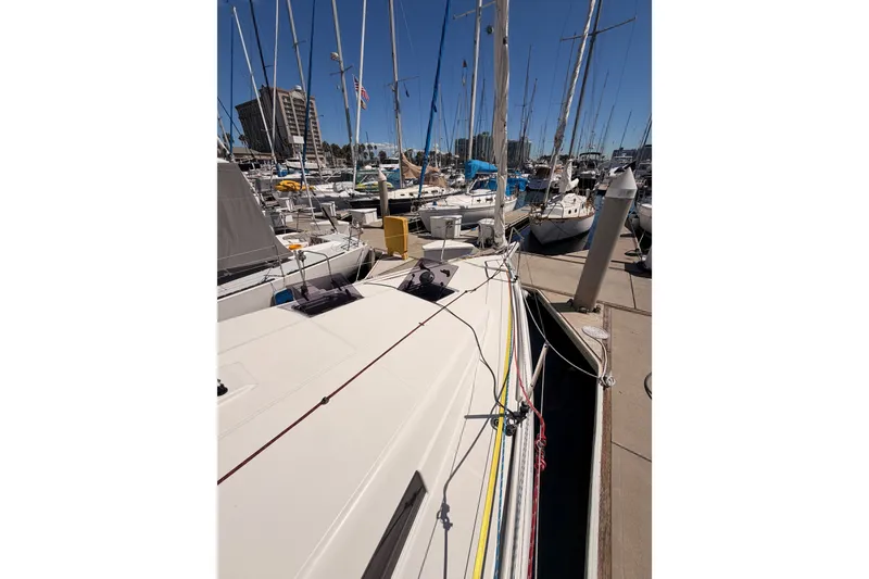 Slide: The Image of 2024 Jeanneau Sun Odyssey 380 docked at a marina, surrounded by other sailboats. - 15