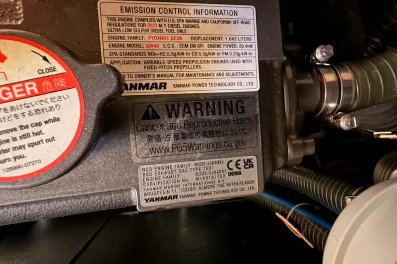 Slide: The Image of Engine warning labels on a 2024 Jeanneau Sun Odyssey 380 sailboat. - 78