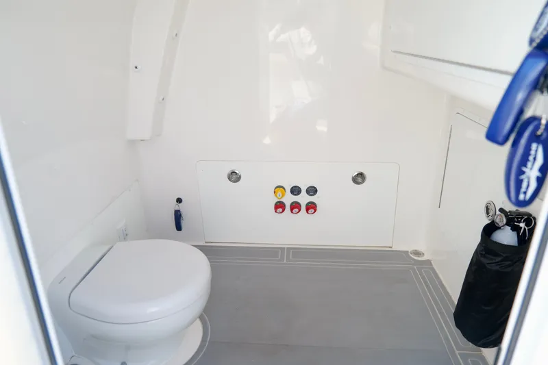 Slide: The Image of Interior of 2022 Invincible 33 Catamaran bathroom with toilet and control panel. - 46