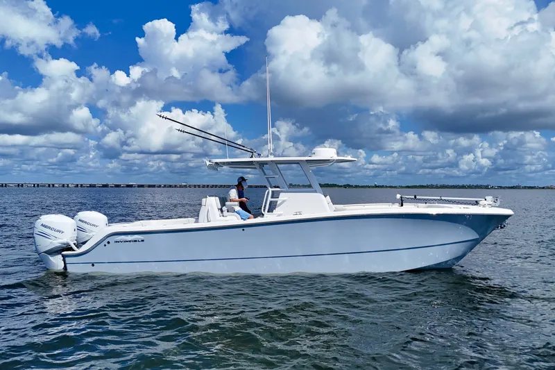 The Image of 2022 Invincible 33 Catamaran on water, featuring twin Mercury engines under a cloudy sky. - 0