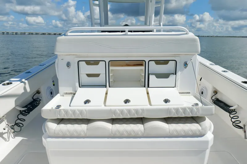 Slide: The Image of 2022 Invincible 33 Catamaran interior with storage compartments and seating, on calm water. - 25