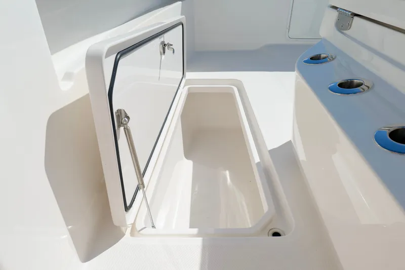Slide: The Image of Open storage compartment on 2022 Invincible 33 Catamaran, featuring sleek design and cup holders. - 42