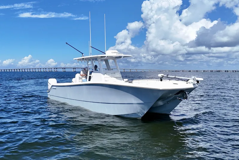 Slide: The Image of 2022 Invincible 33 Catamaran on open water under a clear blue sky. - 1