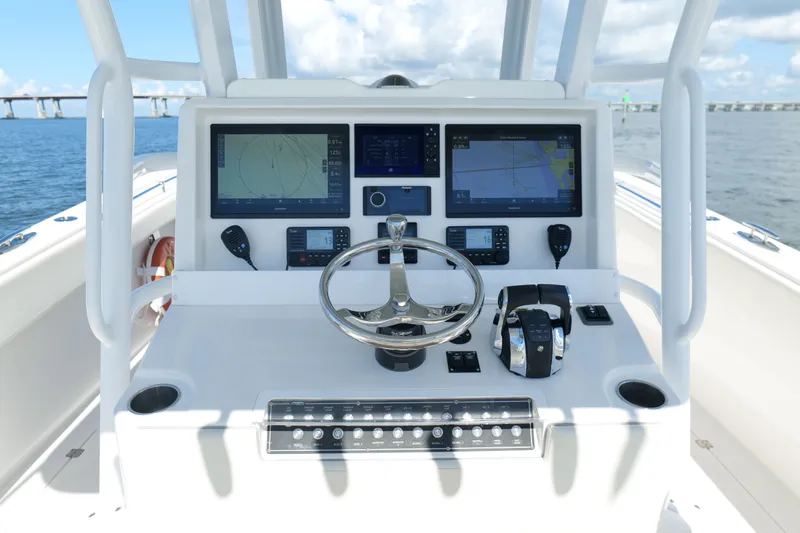Slide: The Image of Control panel of 2022 Invincible 33 Catamaran with navigation screens and steering wheel. - 12