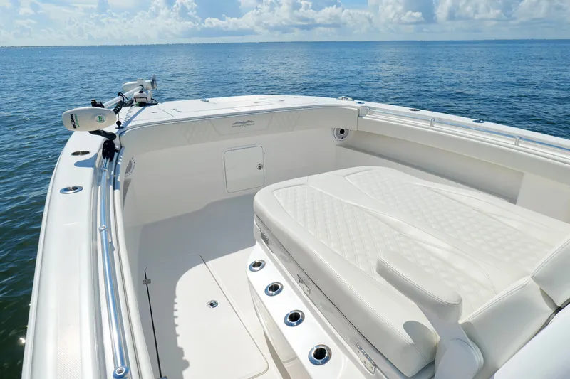 Slide: The Image of 2022 Invincible 33 Catamaran with white seating, on calm ocean waters under a blue sky. - 34