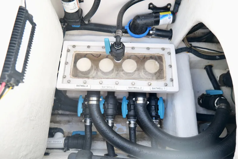 Slide: The Image of Engine compartment of 2022 Invincible 33 Catamaran, showcasing baitwell system and hoses. - 31