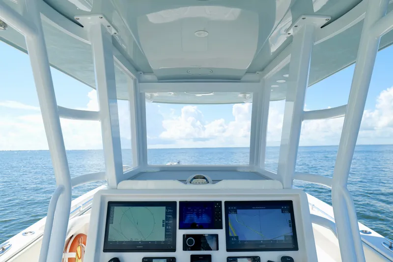 Slide: The Image of Cockpit view of 2022 Invincible 33 Catamaran with navigation screens, overlooking the ocean. - 14