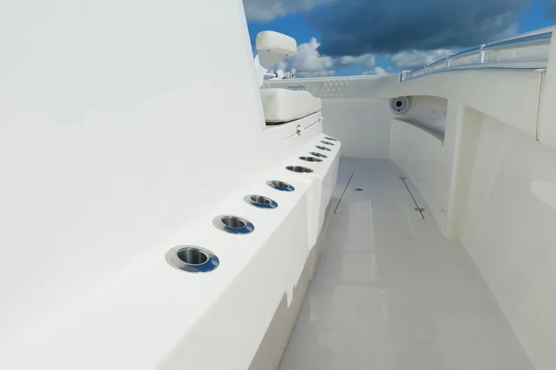 Slide: The Image of 2022 Invincible 33 Catamaran deck with rod holders, sleek design, and clear skies. - 37
