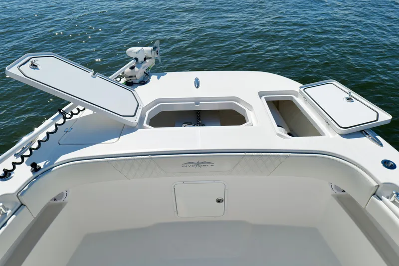 Slide: The Image of 2022 Invincible 33 Catamaran bow with open storage compartments on calm water. - 44