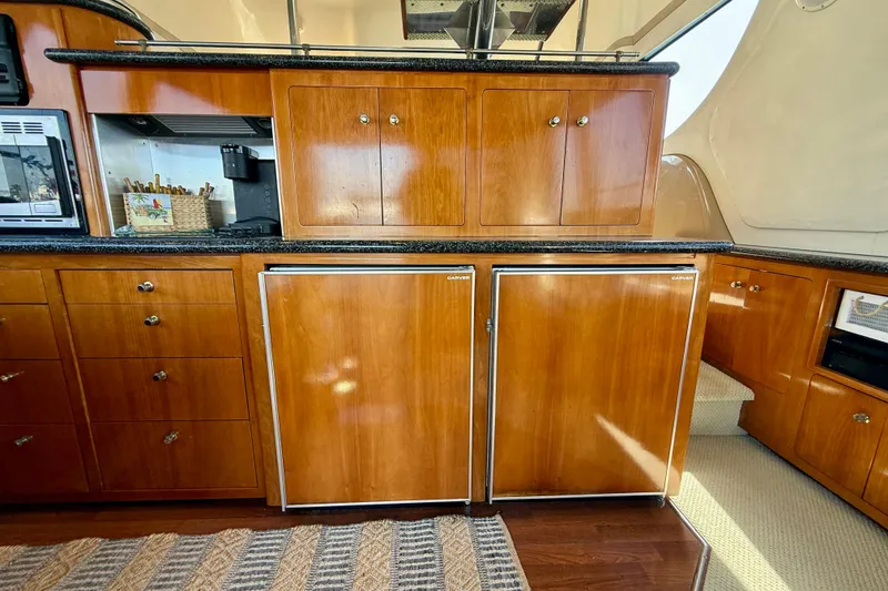 Slide: The Image of Interior of 2000 Carver 53 Voyager yacht with wooden cabinetry and appliances. - 26