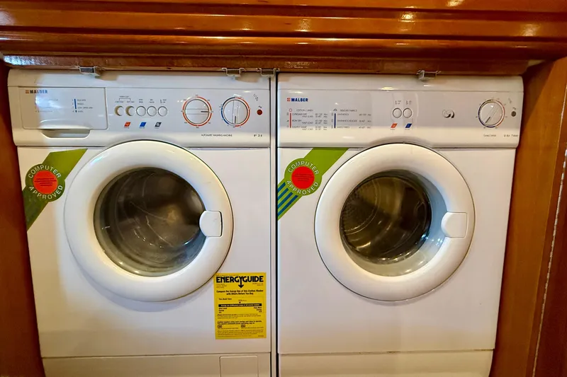 Slide: The Image of Laundry appliances inside a 2000 Carver 53 Voyager yacht, featuring energy-efficient washers. - 53