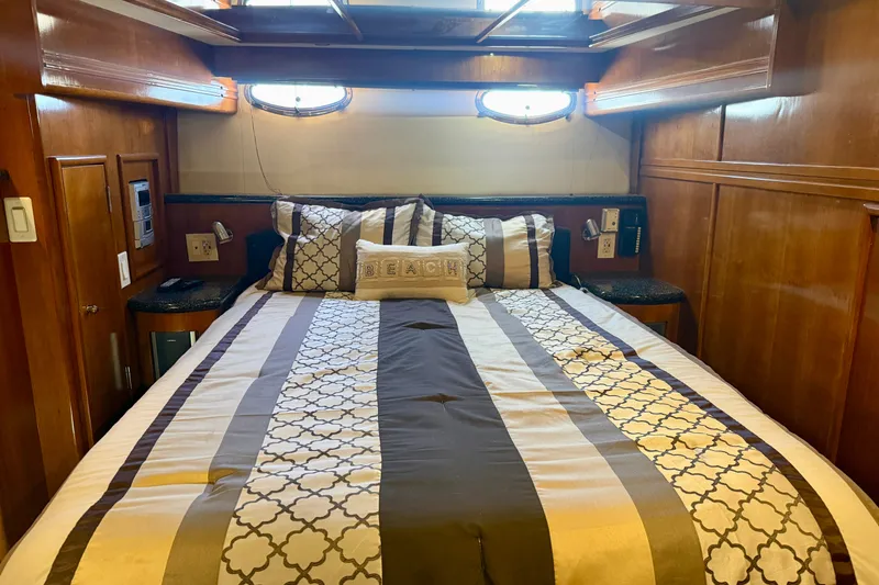 Slide: The Image of Luxurious bedroom interior of 2000 Carver 53 Voyager yacht with elegant bedding and wood paneling. - 43