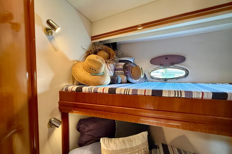 Slide: The Image of Cozy cabin interior of 2000 Carver 53 Voyager with hats and striped bedding. - 38