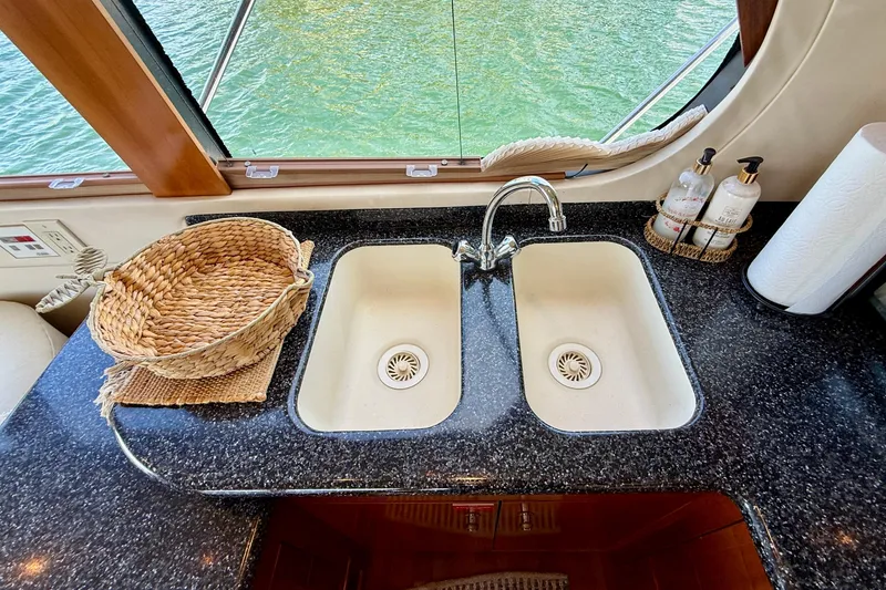 Slide: The Image of Kitchen sink area on a 2000 Carver 53 Voyager yacht with dual basins and wicker basket. - 30