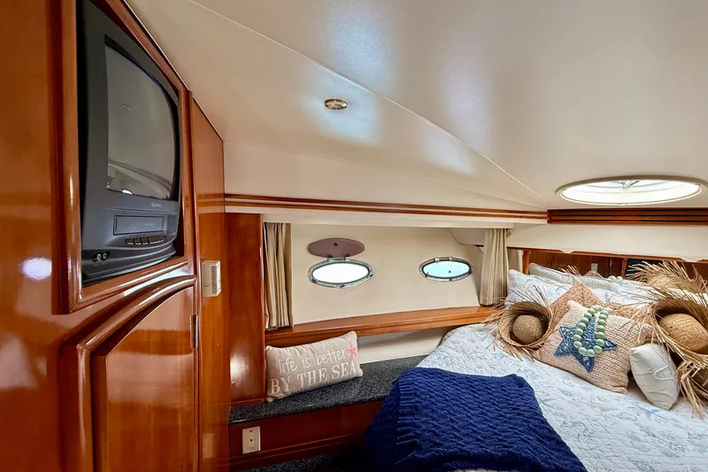 Slide: The Image of Luxurious cabin interior of 2000 Carver 53 Voyager yacht with cozy bedding and vintage TV. - 34
