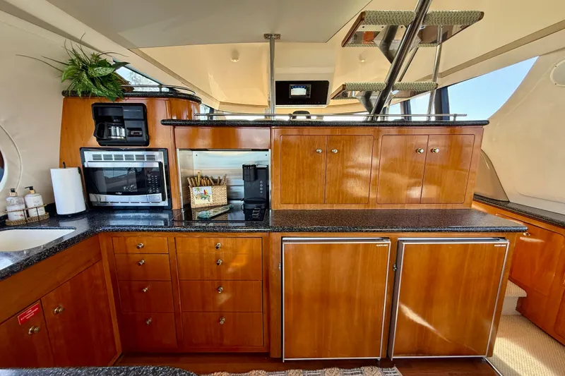 Slide: The Image of Luxurious kitchen interior of 2000 Carver 53 Voyager yacht with wooden cabinetry and modern appliances. - 24