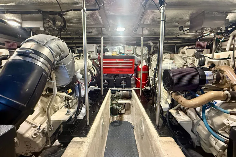 Slide: The Image of Engine room of a 2000 Carver 53 Voyager yacht, featuring mechanical components and tool storage. - 95