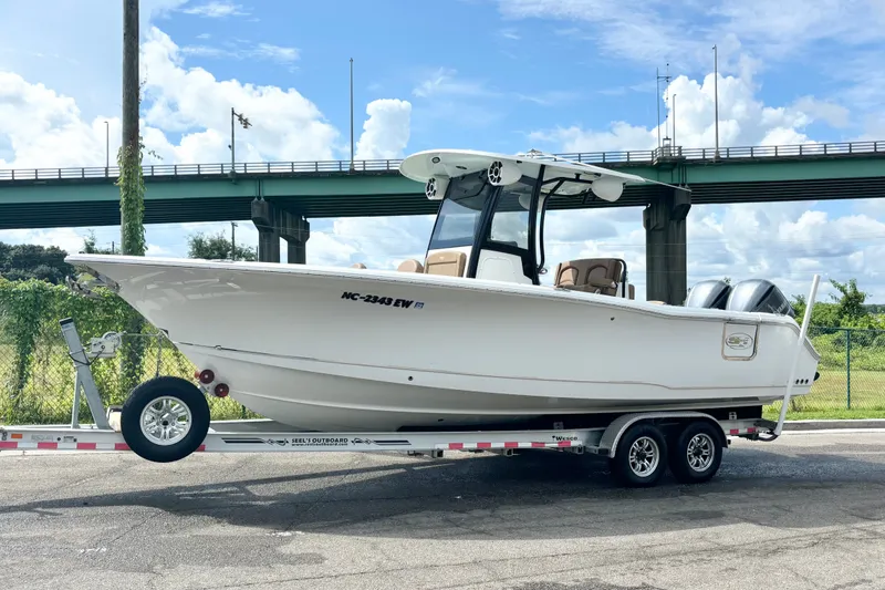 Slide: The Image of 2021 Sea Hunt Gamefish 27FS boat on trailer, parked near a bridge. - 9