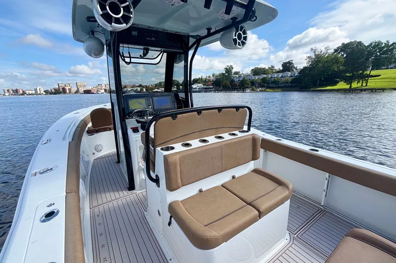 Slide: The Image of 2021 Sea Hunt Gamefish 27FS boat interior with seating, on a calm lake. - 11