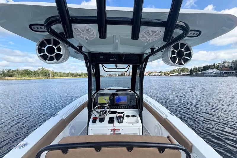 Slide: The Image of 2021 Sea Hunt Gamefish 27FS boat interior with navigation system on calm water. - 12
