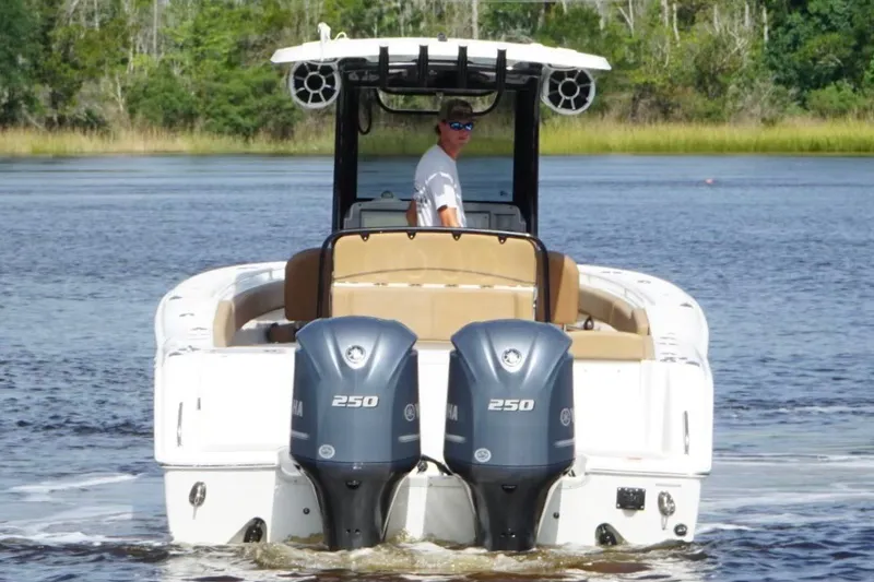 Slide: The Image of 2021 Sea Hunt Gamefish 27FS boat with dual Yamaha 250 engines on a calm lake. - 2