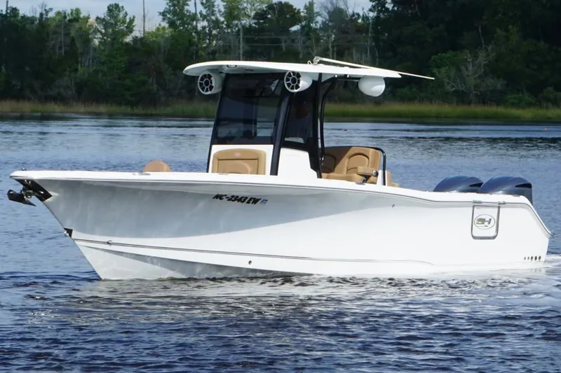 Slide: The Image of 2021 Sea Hunt Gamefish 27FS boat on calm water, featuring sleek design and twin engines. - 8