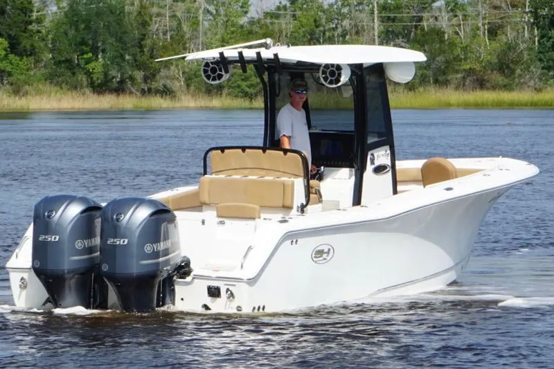 Slide: The Image of 2021 Sea Hunt Gamefish 27FS boat with dual Yamaha 250 engines on a calm lake. - 7