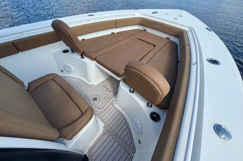 Slide: The Image of 2021 Sea Hunt Gamefish 27FS boat interior with brown seating and white deck. - 17