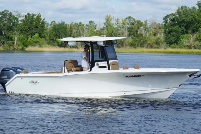 Slide: The Image of 2021 Sea Hunt Gamefish 27FS boat cruising on a calm river. - 3