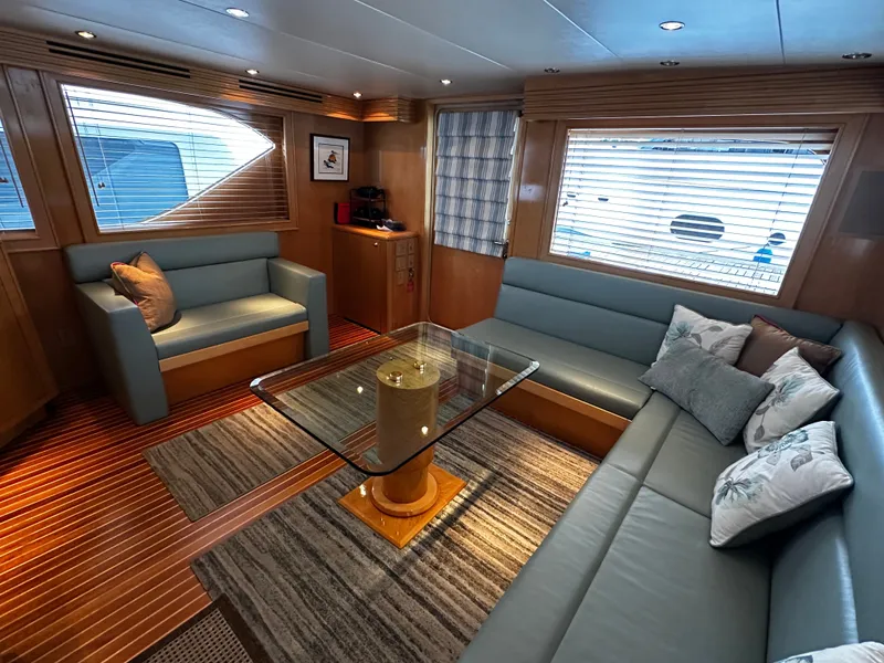 Slide: The Image of Interior of a 2000 Hatteras 70 Convertible with elegant sofas and a glass table. - 8