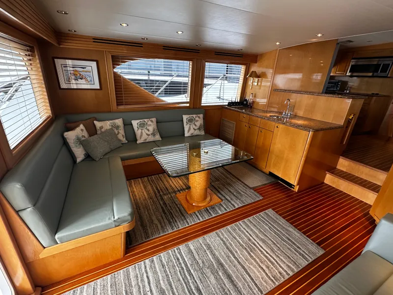 Slide: The Image of Interior of a 2000 Hatteras 70 Convertible with elegant seating area and wooden furnishings. - 6