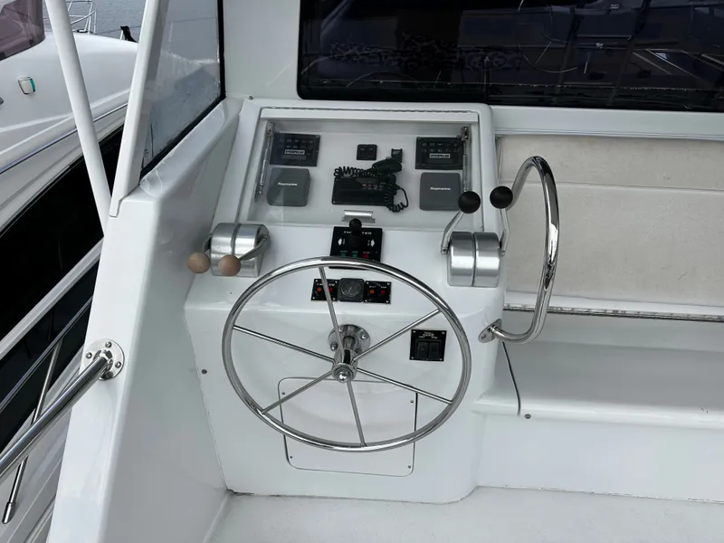 Slide: The Image of Helm of a 2000 Hatteras 70 Convertible with stainless steel wheel and navigation equipment. - 34