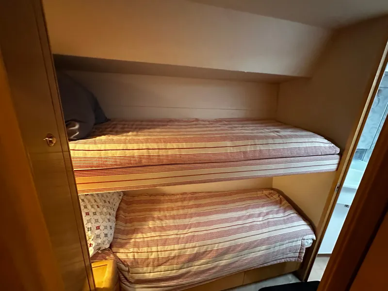 Slide: The Image of Cabin with two bunk beds, striped bedding, warm wood interior. - 14