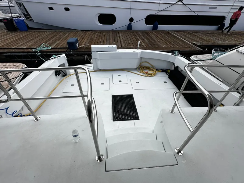 Slide: The Image of The image shows the spacious aft deck of a 2000 Hatteras 70 Convertible, featuring railings and steps. - 27