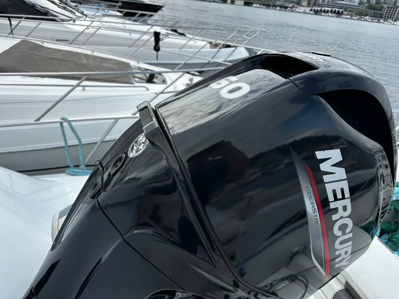 Slide: The Image of A Mercury outboard motor on a boat docked in a marina, surrounded by other boats. - 45