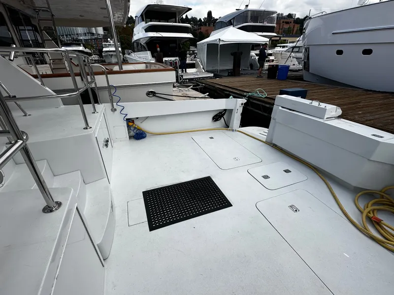 Slide: The Image of The image shows the spacious aft deck of a 2000 Hatteras 70 Convertible, docked at a marina. - 30