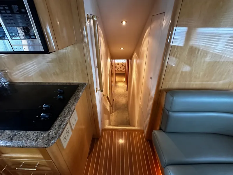 Slide: The Image of Interior of a 2000 Hatteras 70 Convertible with wood flooring and modern kitchen. - 13