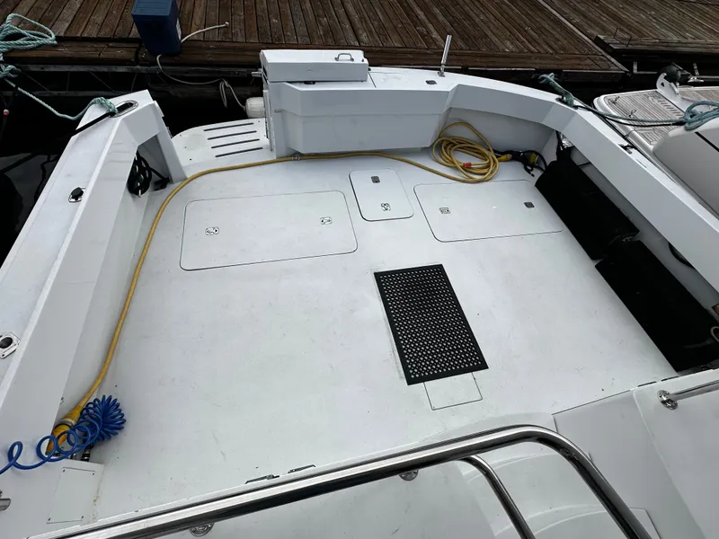Slide: The Image of The image shows the spacious aft deck of a 2000 Hatteras 70 Convertible, moored at a dock. - 28
