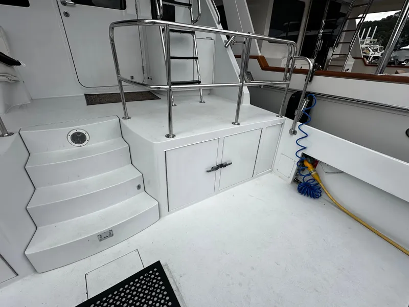 Slide: The Image of The 2000 Hatteras 70 Convertible features a spacious white deck area with stainless steel railings. - 31