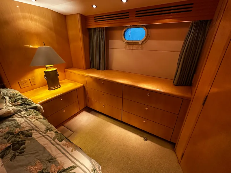 Slide: The Image of A cozy cabin interior with wooden furniture, a floral-patterned bed, and a small porthole. - 17