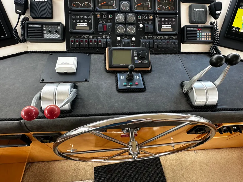 Slide: The Image of The image shows the helm of a 2000 Hatteras 70 Convertible with various instruments and control levers. - 39