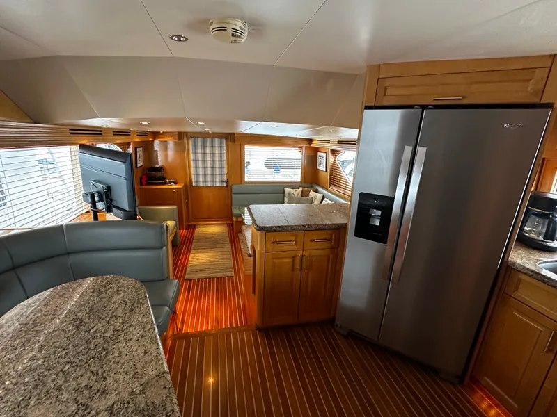 Slide: The Image of Interior of a 2000 Hatteras 70 Convertible with modern kitchen and cozy living area. - 11