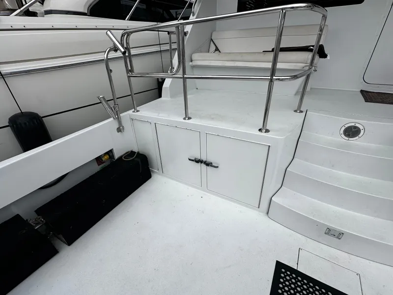 Slide: The Image of The 2000 Hatteras 70 Convertible features a clean deck with white steps and stainless steel railings. - 32